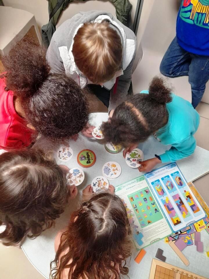 Enfants autour d’une table de jeux à la ludothèque